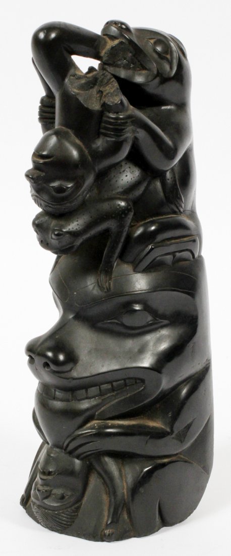 NORTHWEST COAST CARVED ARGILLITE TOTEM: NORTHWEST COAST CARVED ARGILLITE TOTEM, H 11", PROBABLY HAIDA:Carved with two stylized animals, each appears to be consuming a human, and a frog at the center. Not signed. Measures H.11 1/4" x 4 1/2"