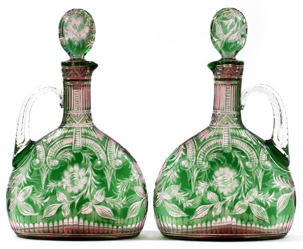 STEVENS & WILLIAMS INTAGLIO CUT GLASS CLARET JUGS: STEVENS & WILLIAMS INTAGLIO CUT TWO-COLOR GLASS CLARET JUGS, C. 1900, PAIR, H 11":Decoration attributed to Joshua Hodgetts for Stevens and Williams. Each intaglio cut green to pink to clear overlay gl