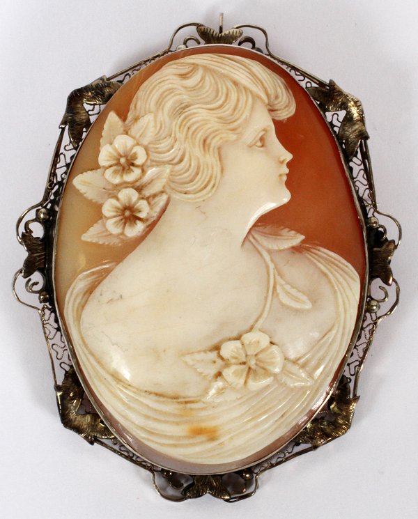 CARVED SHELL CAMEO PENDANT/BROOCH EARLY 20TH C.: CARVED SHELL CAMEO PENDANT/BROOCH, EARLY 20TH C., L 2 3/4":An oval carved shell cameo depicting a young woman in profile, within an silvered metal filigree mount, not marked.