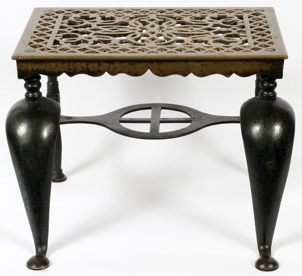 WROUGHT IRON AND BRASS FOOTMAN C1900: WROUGHT IRON AND BRASS FOOTMAN, C1900, H 13", W 18", D 16":having a black painted wrought iron frame with Queen Ann style front legs. Brass pierced design top/step. Pierced cross form design in the ce
