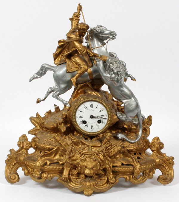 POIRET GILT & SILVERED BRONZE MANTEL CLOCK: POIRET GILT & SILVERED BRONZE MANTEL CLOCK, H 19", W 17":Having a two key wind, with Roman numerals. Gilt bronze frame, surmounted with Middle Eastern figure fighting lion. Measuring H. 19" x 17".