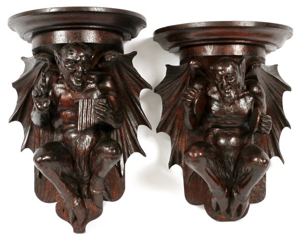GERMAN CARVED OAK FIGURAL WALL MOUNTS 2PCS: GERMAN CARVED OAK FIGURAL WALL MOUNTS, EARLY 20TH C., TWO:Including two wall mount supports, each carved with a gargoyle figure at the base, one playing the flute, the other the cymbals. Measuring L. 