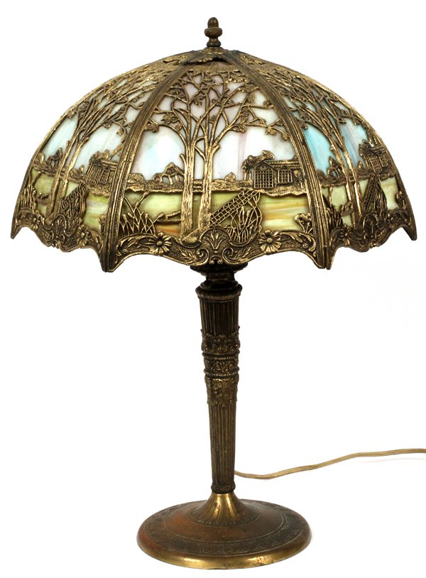 MILLER LAMP CO. SLAG GLASS & GILT METAL LAMP: MILLER LAMP CO. SLAG GLASS & GILT METAL LAMP, C. 1920, H 22", W 17":Having a slag glass shade with gilt metal overlay, decorated in a continuous landscape scene with house. Marked, "M.L. Co." at the u