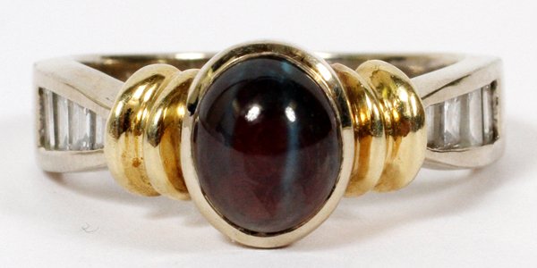 14KT GOLD CAT'S EYE CABOCHON & DIAMOND RING: 14KT GOLD, CAT'S EYE CABOCHON & DIAMOND RING:A 14kt white gold and yellow gold mount centered by a single cabochon in a deep purple color, flanked by baguette diamonds of graduated size. Ring size 7 1