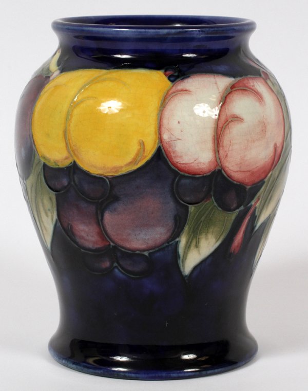 WILLIAM MOORCROFT 'PLUM' POTTERY VASE MID 20TH C.: WILLIAM MOORCROFT 'PLUM' POTTERY VASE, MID 20TH C., H 4":Plum design on a dark blue ground; impressed factory marks and facsimile signature underneath (see additional photo). Measures H.4", Dia.3 1/4"