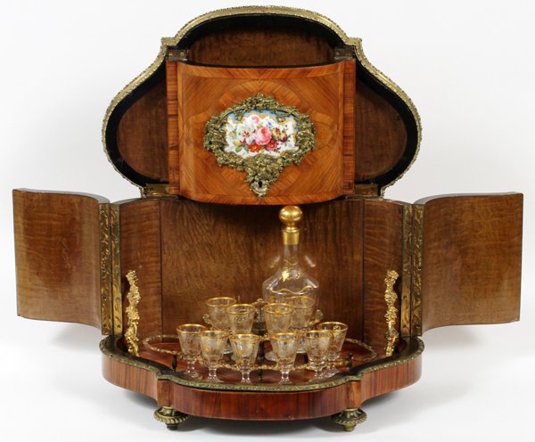 FRENCH ORMOLU & FRUITWOOD INLAY TANTALUS SET: FRENCH ORMOLU & FRUITWOOD INLAY TANTALUS SET, C. 1920, 13 PCS.,:Having a contoured triangular shape of walnut with hinged two piece lid and side panel both with hand painted floral porcelain medallion