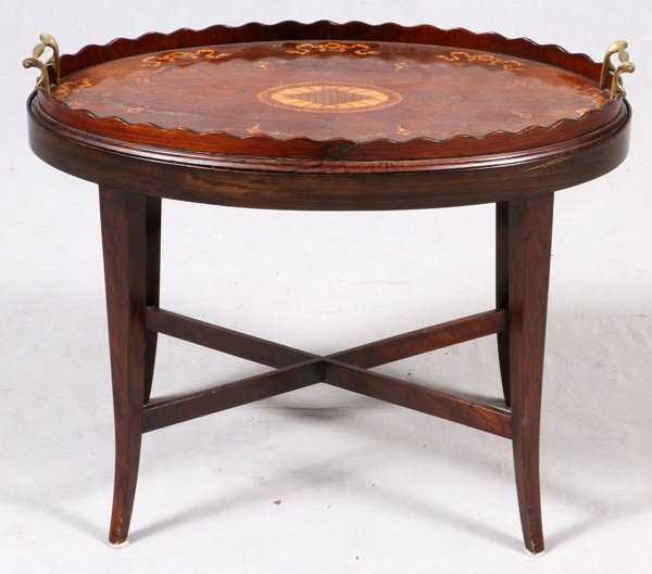 MAHOGANY INLAID OVAL BUTLER'S TABLE: MAHOGANY INLAID OVAL BUTLER'S TABLE, H 19", W 24":Oval form table, with a tray top, raised on splayed legs, with an X-form stretcher. Decorated with an inlaid center medallion, surrounded by ribbon an