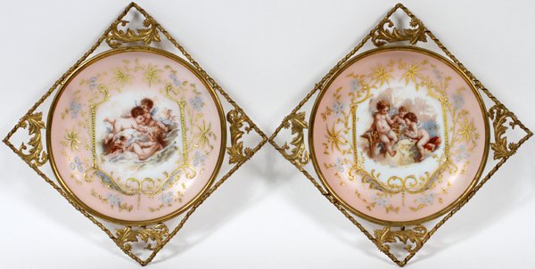 VICTORIAN ENAMELED GLASS WALL HANGINGS 19TH C.: VICTORIAN ENAMELED GLASS & GILT METAL WALL HANGINGS, LATE 19TH C., TWO, W 12" SQUARE:A set of 2 round shallow opaline glass bowls, each is transfer-decorated at the well with cherubs, light pink groun