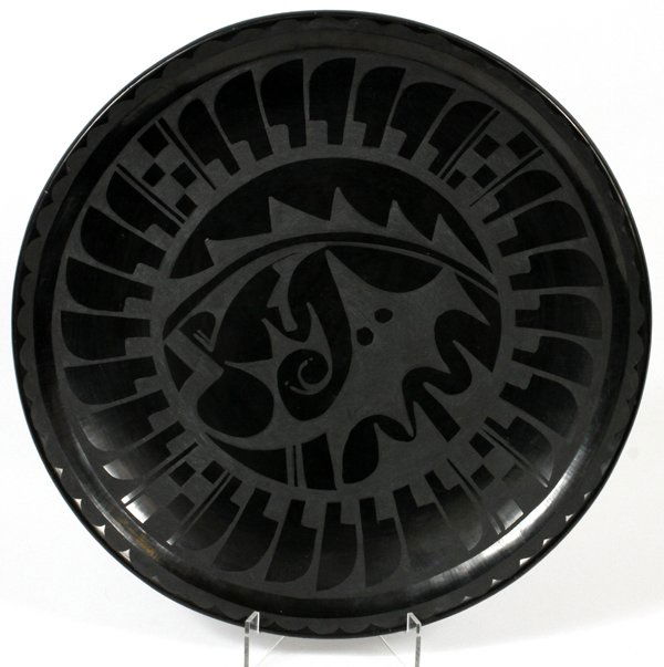 SAN ILDEFONSO CHARGER 1980 CARLOS SUNRISE DUNLAP: SAN ILDEFONSO BLACK ON BLACK CHARGER, 1980, CARLOS SUNRISE DUNLAP, DIA 15":Round form charger, decorated with a feather border, and center abstract design. Signed, "Carlos Sunrise Dunlap, '80" at the