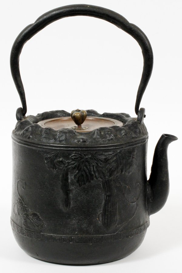JAPANESE IRON TEAPOT W/ BRONZE COVER: JAPANESE IRON TEAPOT WITH BRONZE COVER, H 11", W 8":An iron vessel with bird and leaf design, swing handle, fitted with a bronze cover which is signed at the underside.