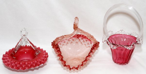 VICTORIAN GLASS BASKETS, 19TH C. THREE: VICTORIAN GLASS BASKETS, 19TH C., THREE, H 6"-10":Including 1 cased white and cranberry basket, 1 heart-form, and 1 cranberry with clear handle.