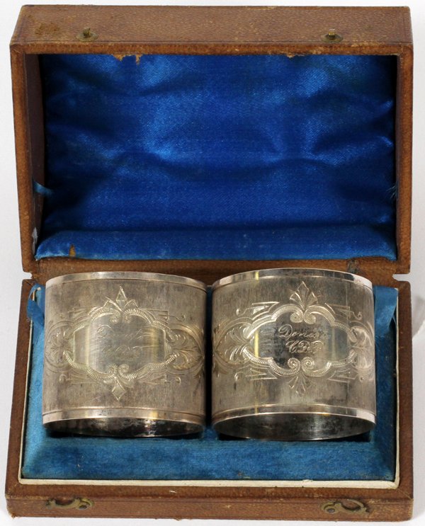 AMERICAN SILVERPLATE NAPKIN RINGS, 19TH C., PAIR: AMERICAN SILVERPLATE NAPKIN RINGS 19TH C., PAIR, ENCASED:A set of 2 silverplate napkin rings, each is identically engraved "Denis to CDP", and stamped 53 within. Fitted in a brown tooled leather box w