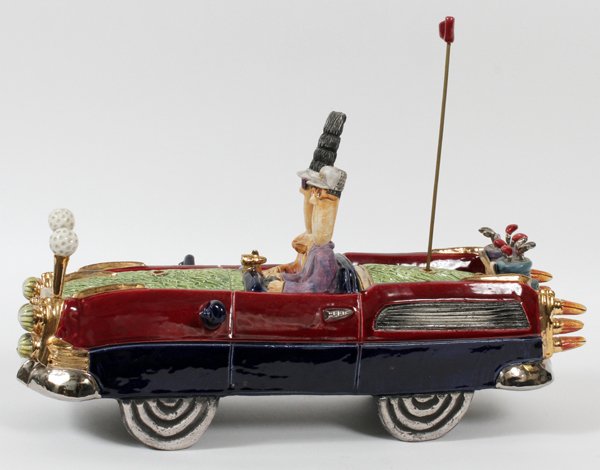 FULL MOON CLAY 324 KT GOLD AND CERAMIC AUTOMOBILE: FULL MOON CLAY 324 KT. YELLOW GOLD AND CERAMIC AUTOMOBILE, H 12", L 19", D 7" "FAIR WAY FAIR LANE":A whimsical ceramic sculpture of a couple driving a golf inspired car. Numbered edition #20/85.