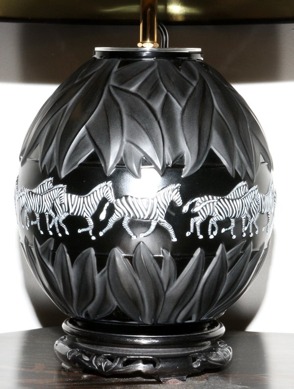 LALIQUE 'TANZANIA NOIR' GLASS VASE AS A LAMP: LALIQUE 'TANZANIA NOIR' GLASS VASE MOUNTED AS A LAMP, H 8":A globular form black glass vase mounted as a table lamp, molded with leaves at either end, having a center panel of parading zebras. Signed,