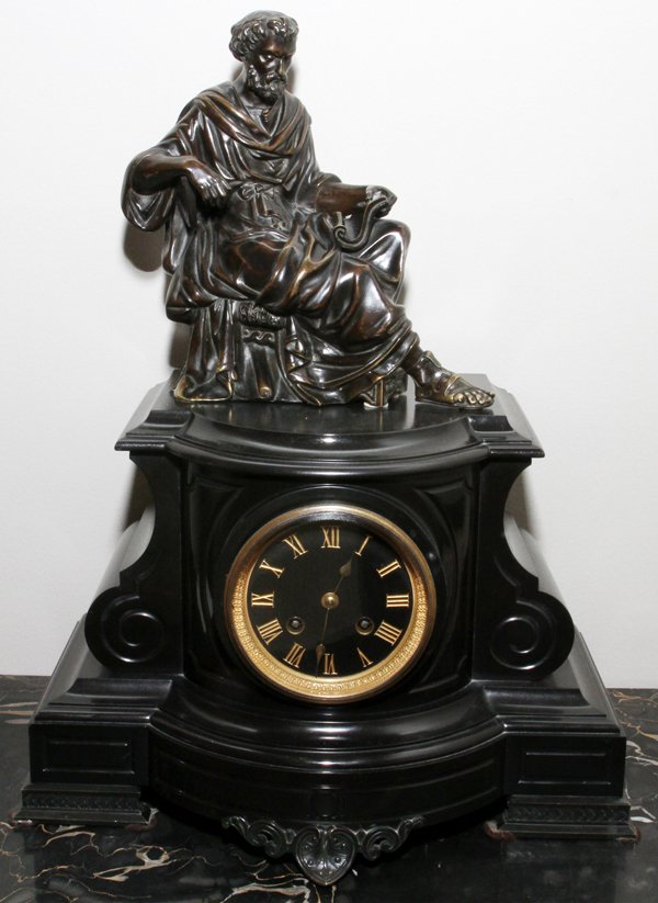 BRONZE & NOIR BELGE MARBLE MANTEL CLOCK 19TH C.: BRONZE & NOIR BELGE MARBLE MANTEL CLOCK, 19TH C., H 18", W 13":Surmounted by a bronze seated male figure, with a black marble base; two key wind movement, and Roman numerals at the face. Measuring H.1