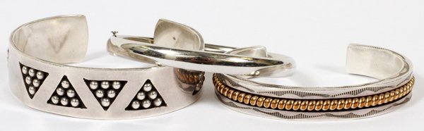 STERLING BRACELETS THREE: STERLING BRACELETS, THREE:Including 2 cuff style bracelets, one is stamped "Taho" and has gold fitted decoration, the other is Mexican and has a bead motif; and 1 hinged bangle bracelet. Three items t