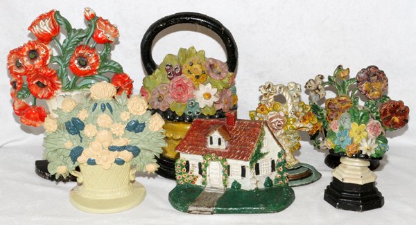 CAST IRON DOORSTOPS C. 1880-1930 SEVEN: CAST IRON DOORSTOPS, C. 1880-1930, SEVEN, H 6"-10 1/2":Including 6 floral arrangements and 1 cottage. For a high resolution photo CLICK HERE