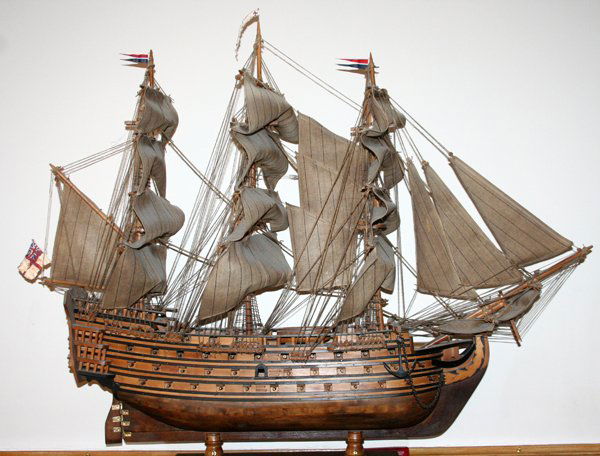 HMS VICTORY SHIPS MODEL ON INTEGRAL BOAT STAND: HMS VICTORY, SHIPS MODEL ON INTEGRAL BOAT STAND, H 34", L 42":Depicting the British Ship of the Line HMS Victory, flagship of Lord Nelson at the battle of Trafalgar, complete with sails, rigging, anch