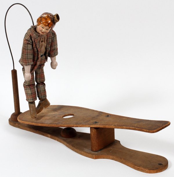 JOLLY JIGGER TOY C 1910 SCHOENHUT: JOLLY JIGGER TOY C 1910, SCHOENHUT H 12" "DUDE":Dancing boy in cotton plaid suit suspended from wire dances on wood platform with stencil "Jolly Jigger" patent applied, H. 12". Stencil in red around o
