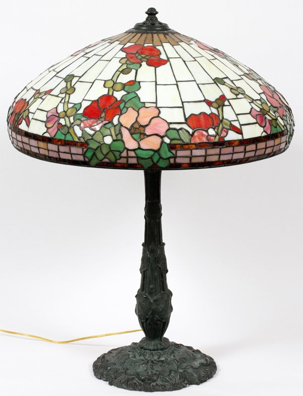WILKINSON LEADED GLASS TABLE LAMP EARLY 20TH C.: WILKINSON LEADED GLASS TABLE LAMP, EARLY 20TH C., H 31", DIA 22":Leaded glass shade with red and pink floral sprays on a white ground, raised on a patinated metal base marked "Wilkinson Co., Brooklyn,