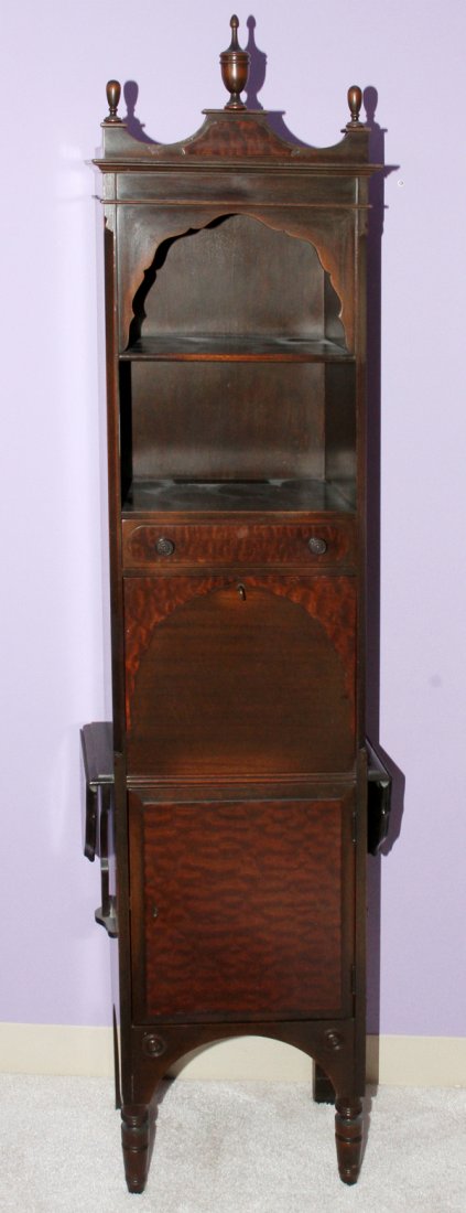 WALNUT NARROW CABINET C. 1920: WALNUT NARROW CABINET, C. 1920, H 75", W 18":With a center fall-front desk, as well as one drawer, two open shelves, and a lower enclosed cabinet, as well as two drop-style hinged leaves at the side, 