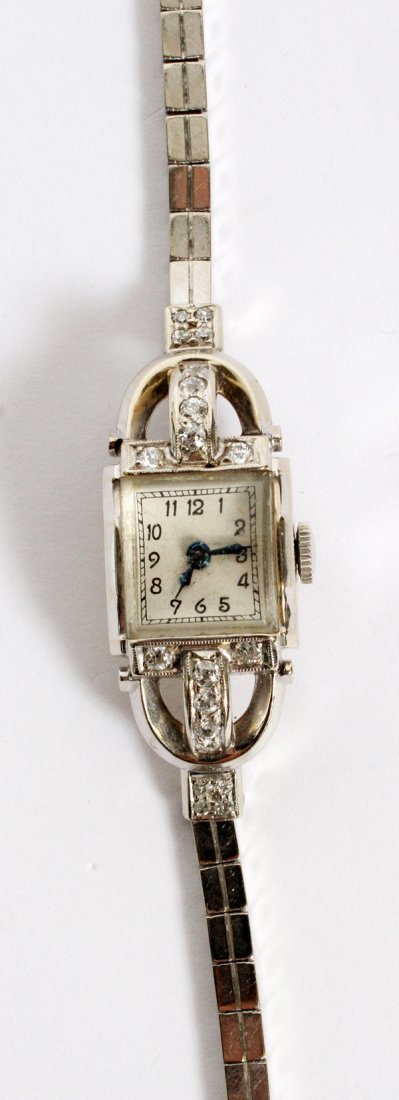 14KT WHITE GOLD & DIAMOND LADY'S WRISTWATCH C. 1940: 14KT WHITE GOLD & DIAMOND LADY'S WRISTWATCH, C. 1940, L 6":Enhanced with small diamonds, Arabic numerals, the reverse with an engraved GRF monogram. The case and the strap are both stamped "14K". Weig