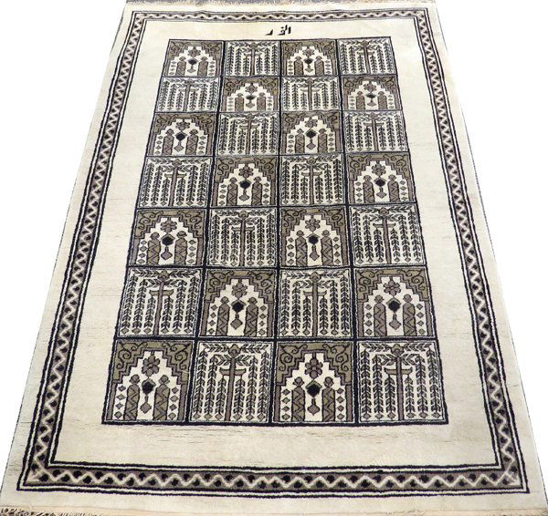 INDIAN HAND KNOTTED WOOL RUG, 9' 0" X 6' 7": INDIAN HAND KNOTTED WOOL RUG, 9' 0" X 6' 7", SIGNED:Having three borders including a wide white primary border the field consists of 28 small rectangular panels which resemble prayer rug designs. Sign