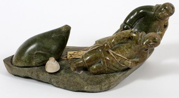 INUIT SOAPSTONE FIGURAL CARVING 1975: INUIT SOAPSTONE FIGURAL CARVING, 1975, H 5", W 10":Two carved skims with seal. Figures are held to base by pegs. For a high resolution photo CLICK HERE