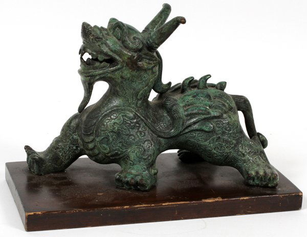 PATINATED BRONZE FU DOG FOR FREDERICK COOPER: CHINESE STYLE PATINATED BRONZE FU DOG FOR FREDERICK COOPER, H 7", L 10 1/2":Mounted on a wood base with a label underneath, "Frederick Cooper Chicago" (see additional photo). Measures H.8 1/2" x 12" x