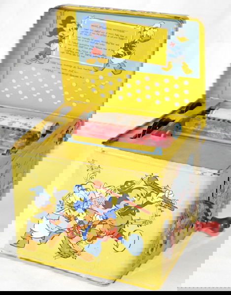 DISNEYLAND WIND-UP 'MELODY PLAYER', W 7 1/2": DISNEYLAND WIND-UP 'MELODY PLAYER', W 7 1/2", H 7", D 6 3/4":Depicting Dumbo, Donald Duck, Mickey Mouse, and one roll at the inside and four additional rolls in a separate box.