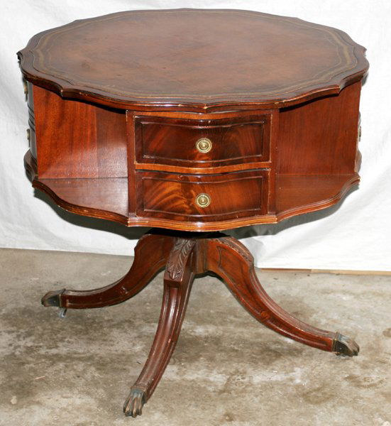 DUNCAN PHYFE STYLE MAHOGANY LIBRARY TABLE: DUNCAN PHYFE STYLE MAHOGANY LIBRARY TABLE, MID 20TH CENTURY, H 30", DIA 32":Inset tooled leather top, swivel base comprising eight drawers and four shelves, raised on four down swept legs ending in br