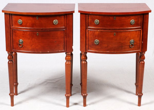 SHERATON STYLE MAHOGANY TWO DRAWER END TABLES: SHERATON STYLE MAHOGANY TWO DRAWER END TABLES, C.1997, H 32", W 22", D 16":Two arched drawer facades, brass pulls, turned spindle legs. Bombay co. For a high resolution photo