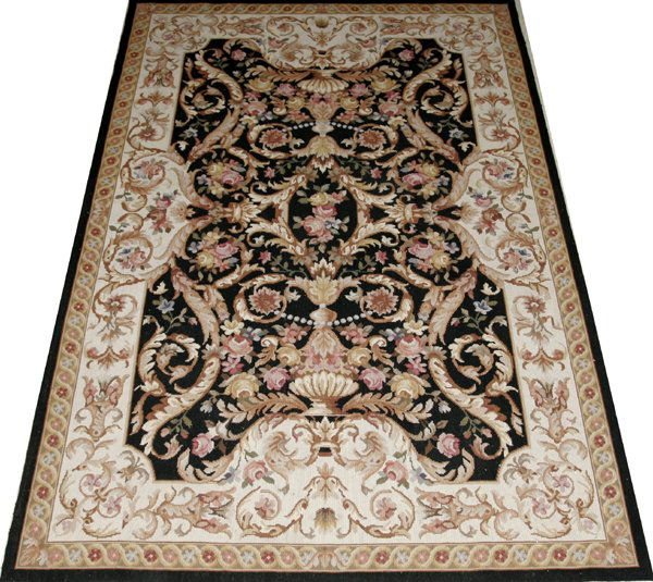 ENGLISH NEEDLEPOINT RUG, 71"x47": ENGLISH NEEDLEPOINT RUG, 71" X 47":Hand made. Not lined. Made by Ada West. Black ground with overall floral motif with urns, ivory border with pink flowers. From the Collection of Sybil Jaques, Lakesh