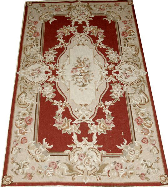 ENGLISH NEEDLEPOINT RUG, 58"x34": ENGLISH NEEDLEPOINT RUG, 58" X 34":Hand made. Not lined. Oval central cartouche with flowers against a rose ground, beige/gray border. Made by Ada West. From the Collection of Sybil Jaques, Lakeshore