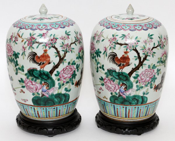 CHINESE ENAMELED PORCELAIN JARS PAIR: CHINESE ENAMELED PORCELAIN JARS, PAIR, H 12", DIA 8":Each is decorated with chickens among flowering trees, raised on a separate wood base. Not marked. From the collection of Mr. Arthur Roshak, Grosse