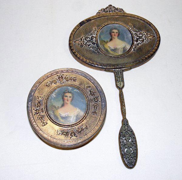 APOLLO STUDIOS, N.Y., GILT METAL DRESSER JAR: APOLLO STUDIOS, N.Y., GILT METAL DRESSER JAR DIA 4 1/2" & MIRROR L 11", #3189, 2PCS.:Mirror having a pierced handle. Both having hand painted female figures, scroll, and ribbon designs. Dresser jar ha