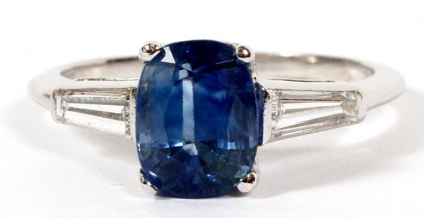 2.55 CT SAPPHIRE AND PLATINUM RING: 2.55 CT SAPPHIRE AND PLATINUM RING, SIZE 7 1/2:A 2.55ct blue sapphire flanked by two tapered baguette diamonds, with a platinum setting. Weighing approximately 4.6 grams.