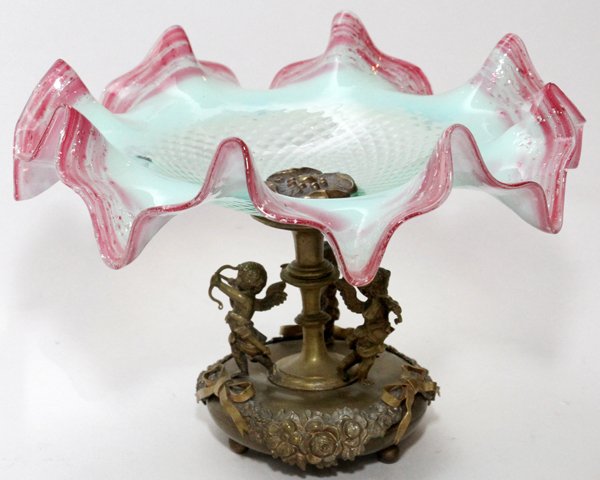 OPALESCENT GLASS AND BRASS FIGURAL COMPOTE C.1900: OPALESCENT GLASS AND BRASS FIGURAL COMPOTE, C.1900, H 6 1/2", DIA 9 1/2":An opalescent glass bowl with ruffled edges on a brass base with three cupids.