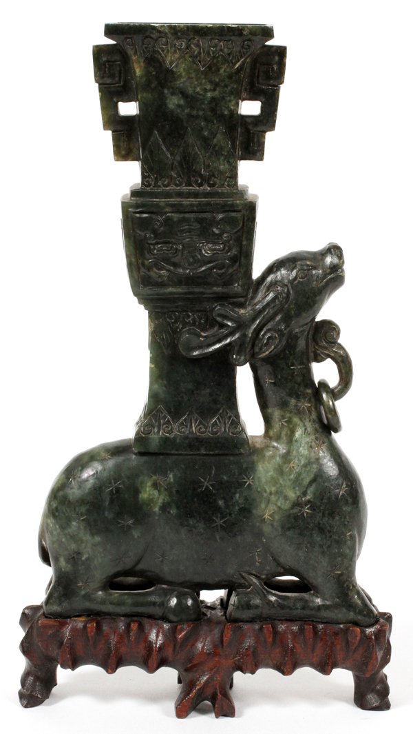 CHINESE CARVED SERPENTINE DEER FORM URN: CHINESE, CARVED SERPENTINE, DEER FORM URN, H 8":Depicts green serpentine reclining deer with tall urn emanating from the deer's back. Mounted on carved footed wood stand.
