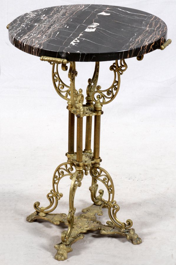 ROUND MARBLE TOP AND BRASS PEDESTAL TABLE: ROUND MARBLE TOP AND BRASS, PEDESTAL TABLE, H 26":having a round black marble top with a pedestal base with pierced scroll design supports securing the top above four shafts in the center of the pedes