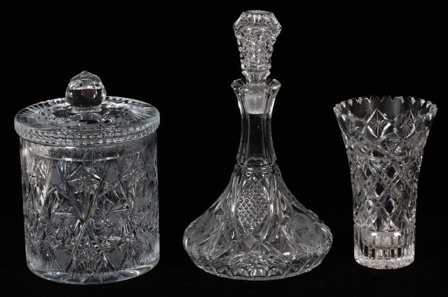 CUT GLASS BISCUIT JAR VASE AND DECANTER 3 PIECES: CUT GLASS BISCUIT JAR, VASE AND DECANTER THREE PIECES: Biscuit jar with cover, hand cut and probably made in Czechoslovakia circa 1960 H 9.5". Vase is hand cut 7.5" and decanter is pressed glass.