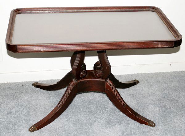 DUNCAN PHYFE STYLE MAHOGANY COFFEE TABLE: AMERICAN, DUNCAN PHYFE STYLE MAHOGANY COFFEE TABLE, C. 1950, H 17", W 16 1/2", L 28 1/2":Having brass claw feet; carved acanthus leaf cabriole legs; glass tray top. Ex estate Frank J Sladen Jr., Gross