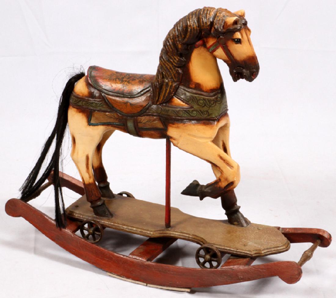 CARVED WOOD HAND PAINTED ROCKING HORSE 20TH CENTURY: CARVED WOOD, HAND PAINTED ROCKING HORSE, 20TH CENTURY H 26" W 12" L 32":Convertible design as a rocker and detaches with cast iron wheels and traverses on the wheels. Carved saddle, bridle, mane, brea