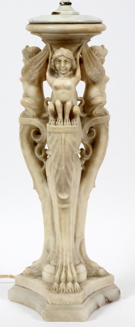 ALABASTER GREEK SPHINX TABLE LAMP 20TH CENTURY: ALABASTER GREEK SPHINX TABLE LAMP, 20TH CENTURY, H 35", DIA 17":A carved alabaster three-light lamp. Early 20th century. Standard elaborately carved as a foliate column flanked by three winged Greek s