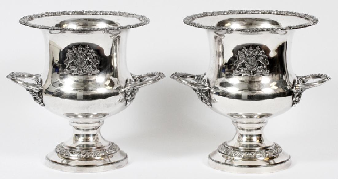 SILVERPLATE WINE COOLERS PAIR: SILVERPLATE WINE COOLERS, PAIR, H 10", W 11", DIA 9":Each with handles and a crest at the body. Estate of Frederick C. and Malora Matthaei.