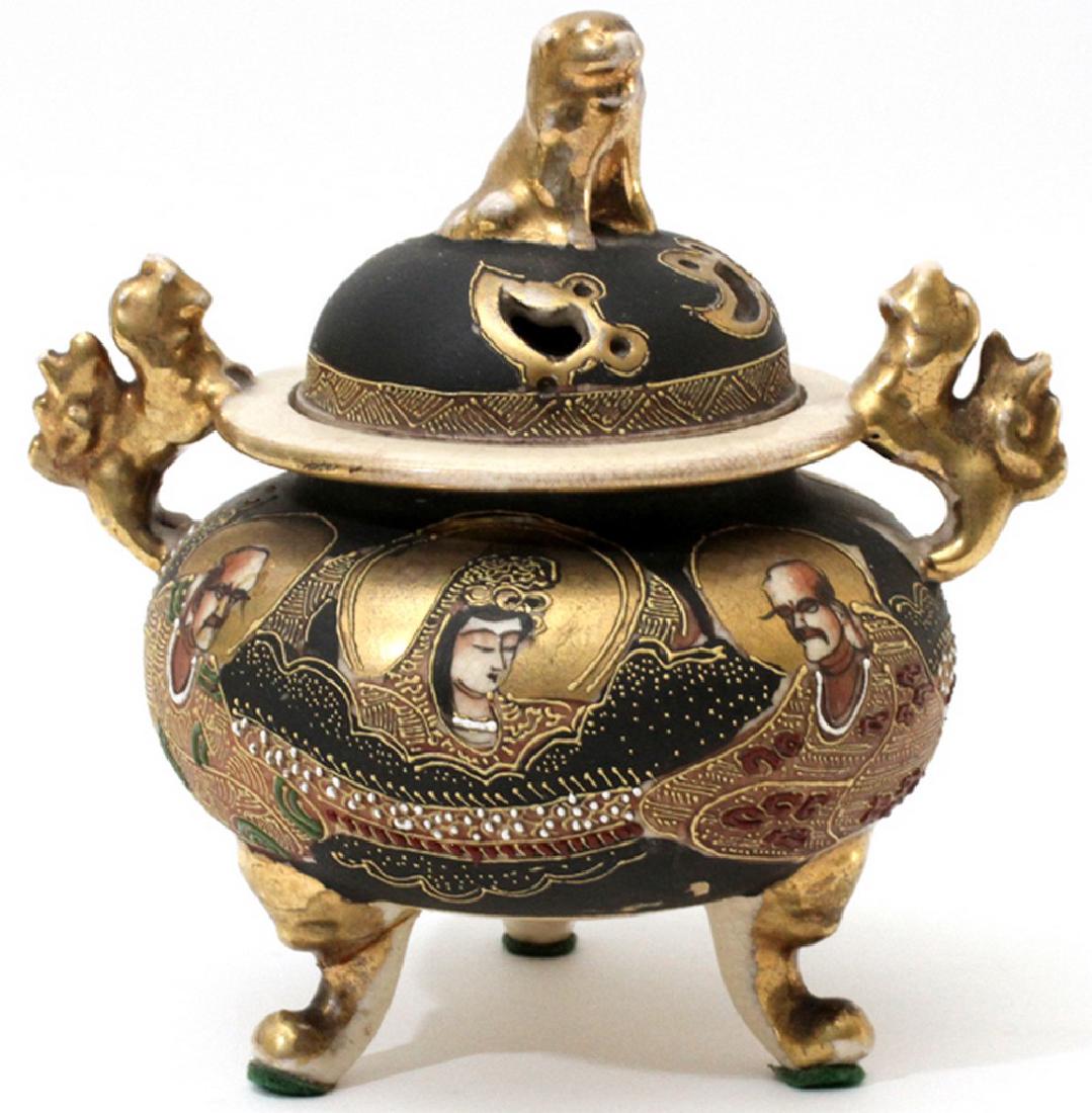 JAPANESE SATSUMA EARTHENWARE CENSER C. 1920: JAPANESE SATSUMA EARTHENWARE CENSER, C. 1920, H 6 1/2", L 6":Having a Fu lion form finial with pierced top. Depicting a Guanyin figure with attendants. Tri-footed with a pair of Fu lion handles. Marke