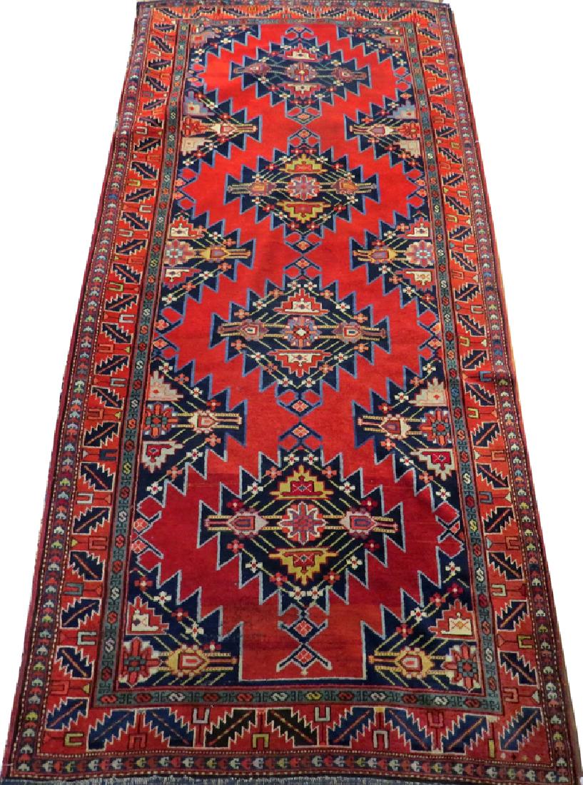 RUSSIAN ANTIQUE ALL WOOL CARPET 1900-1920: RUSSIAN ANTIQUE ALL WOOL CARPET, 1900-1920, 10' X 4' 6":A red-orange overall color, decorated in geometric motif, accented in blue, green, red, and yellow.