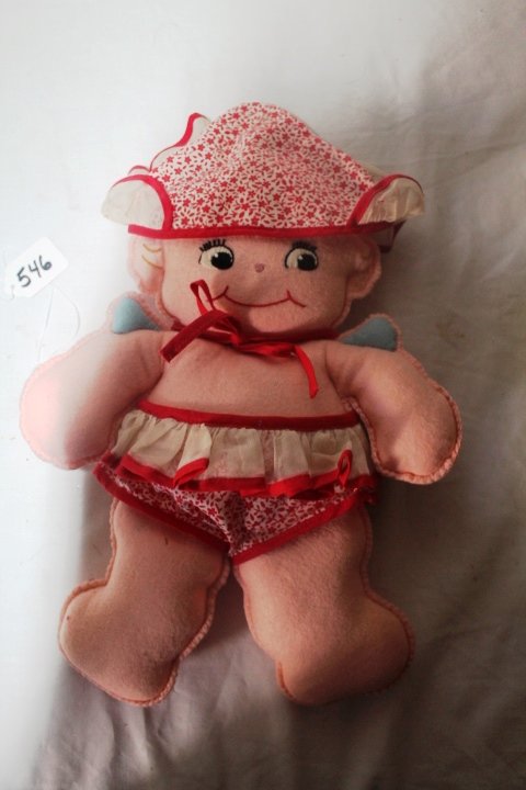 14"; OLD CLOTH KEWPIE WITH CLOTH FACE, PINK FELT FLAT: 14"; OLD CLOTH KEWPIE WITH CLOTH FACE, PINK FELT FLAT STUFFED, MADE FROM OLD MCCALL PATTERN. WEARING ORIG. RED AND WHITE COTTEN SUNSUIT AND BONNET.. WEAR ON BACK OF BOTH LEGS AND BACK OF LEFT ARM. GOO