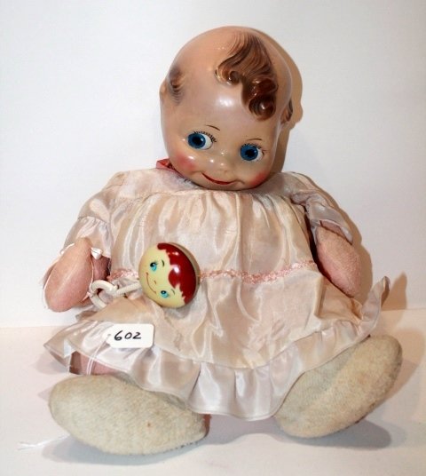 16" SITTING COMPOSITION HEAD - CLOTH BODY STUFFED.: 16" SITTING COMPOSITION HEAD - CLOTH BODY STUFFED. CRAZING ON BACK AND SIDE OF HEAD. ORIGINAL DRESS WITH RATTLE. FAIR CONDITION.