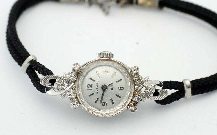 Circa 1971 WOMEN's 23 Jewel BULOVA 14 KARAT White Gold: Women's 14 Karat White Gold BULOVA With Original String Band. Circa 1971. Calibre 5AT 23 Jewel Hand Wind Movement. Watch Is Currently In Working Order. No Buyer's Premium.